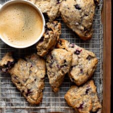 vegan blueberry lemon poppy seed scones on cooling rack with a cup of coffee