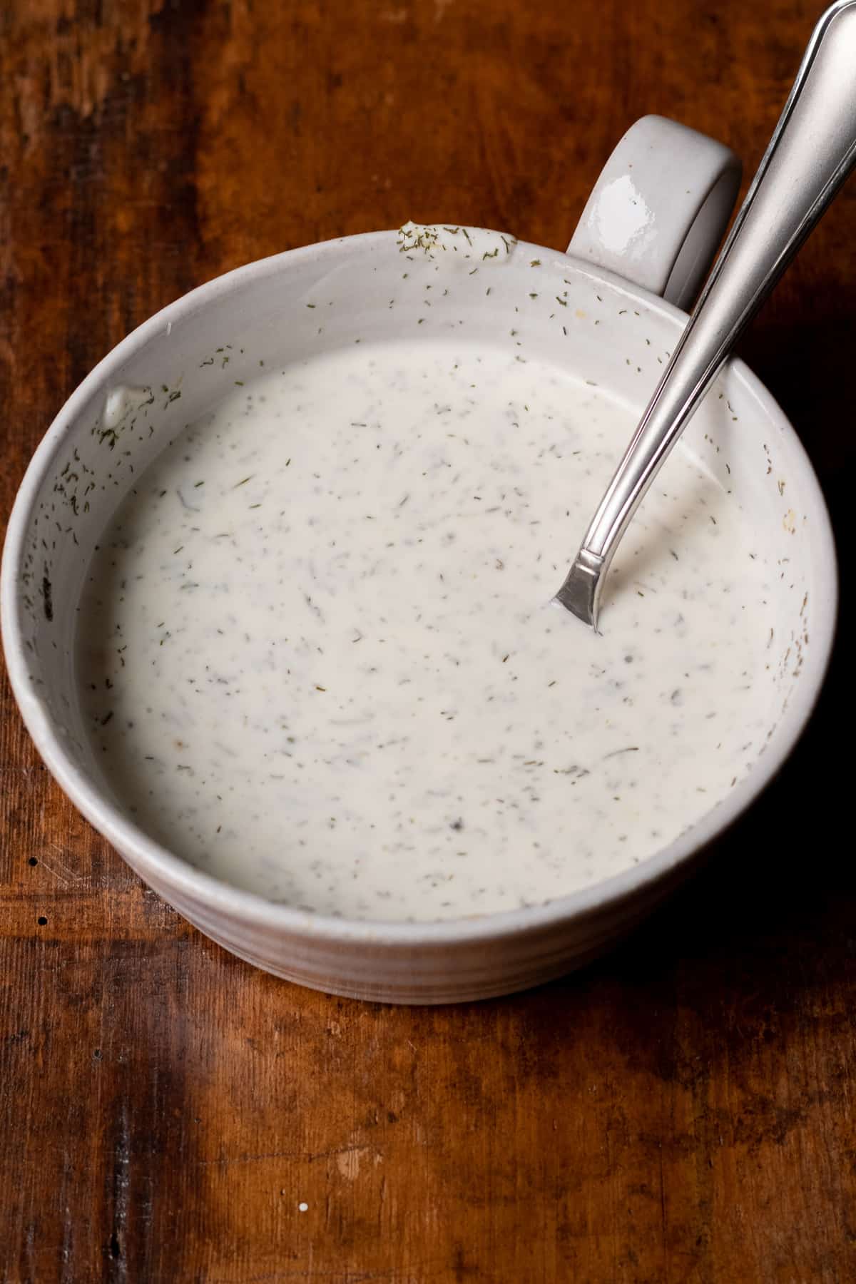 creamy dill sauce ingredients mixed together in white bowl