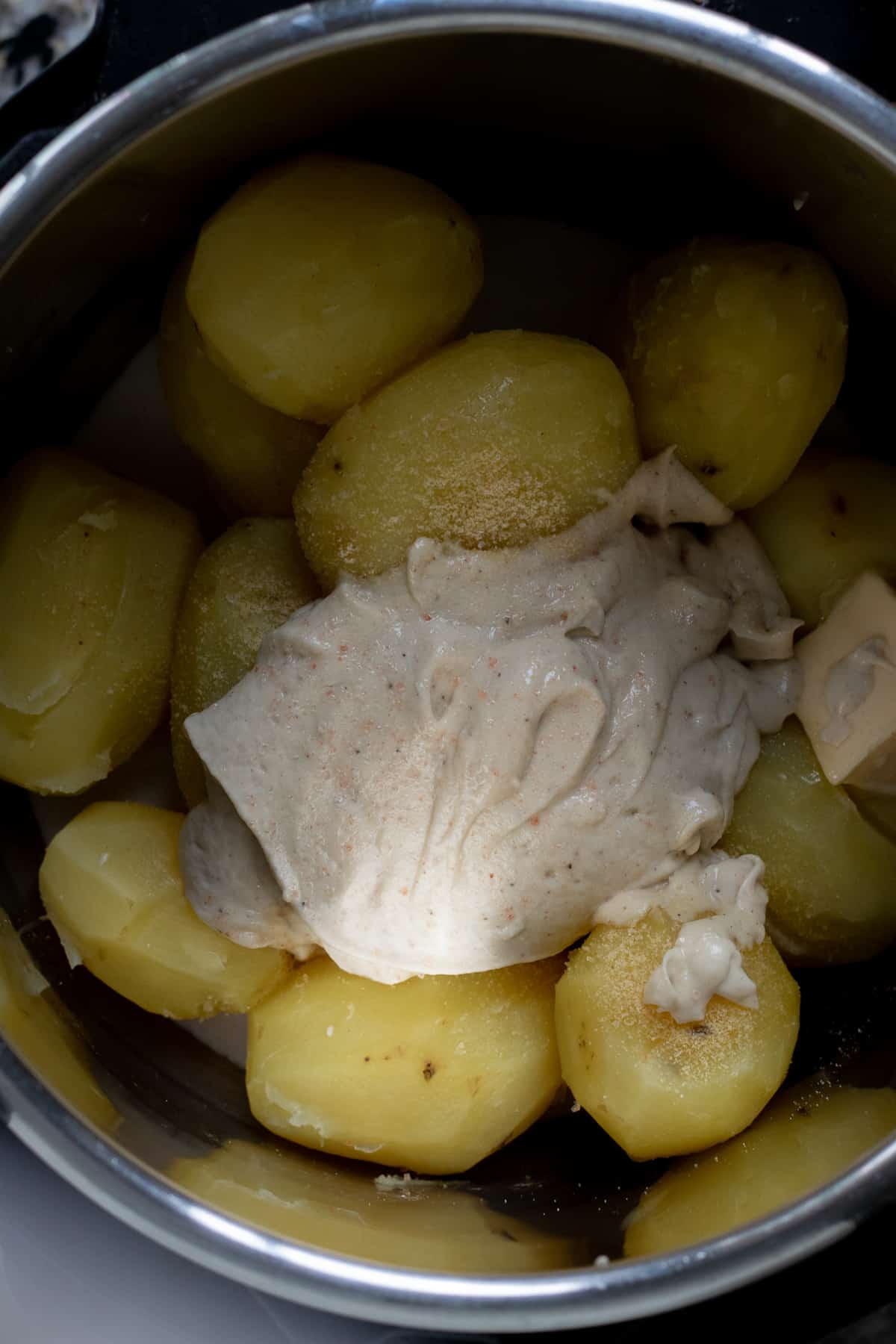 Cooked gold potatoes with mashed potato ingredients added on top.