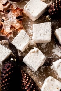 Marshmallows on parchment paper surrounded by ornaments.