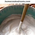 Cashew sour cream in bowl with gold spoon and overlay text describing recipe.
