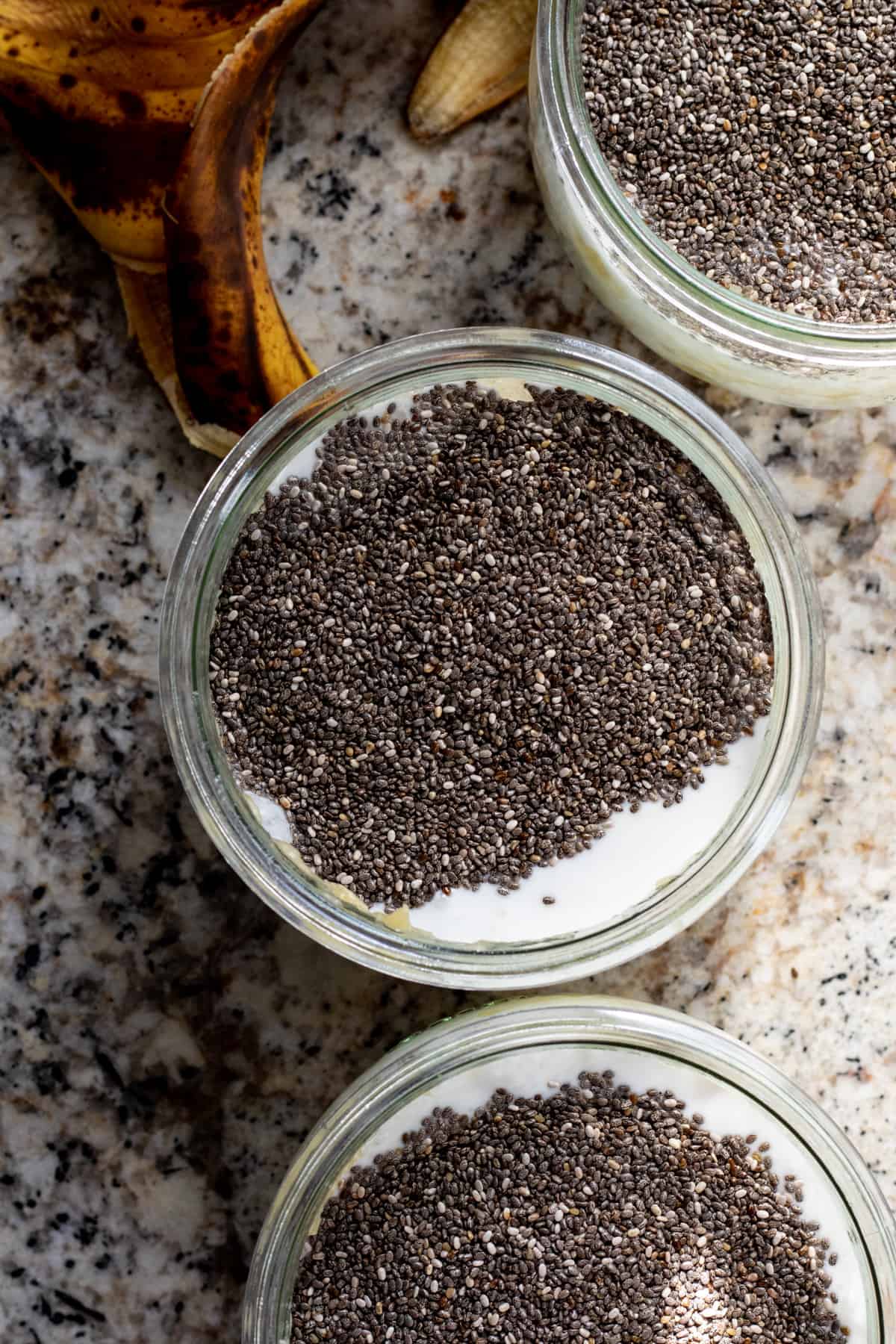 Milk with chia seeds on top in glass jar.