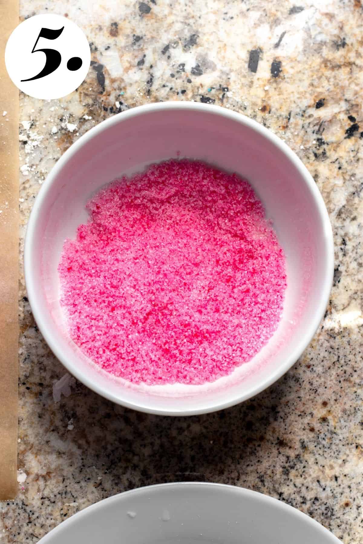 Pink sugar in white bowl.