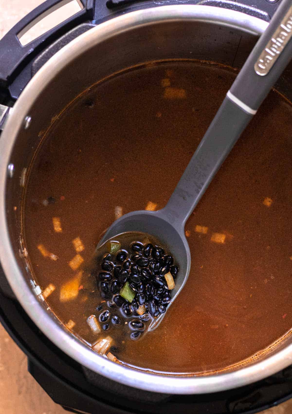 Beans and broth added to Instant Pot before pressure cooking.