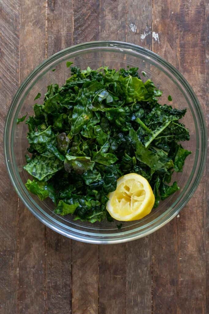 Kale in glass bowl massaged with lemon juice.