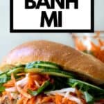 Banh mi sandwich topped with quick pickle vegetables on wooden table and text overlay for pinterest.