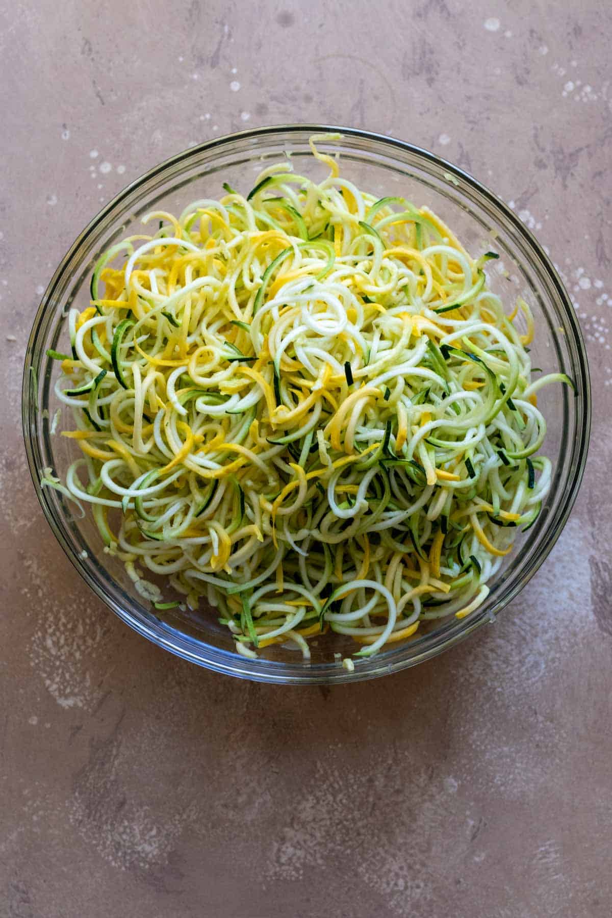 Spiralized zucchini and summer squash in glass bowl.