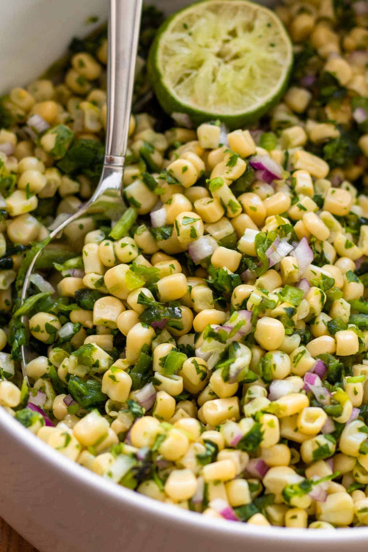 Chili-Corn Salsa with Lime wedge and large spoon.
