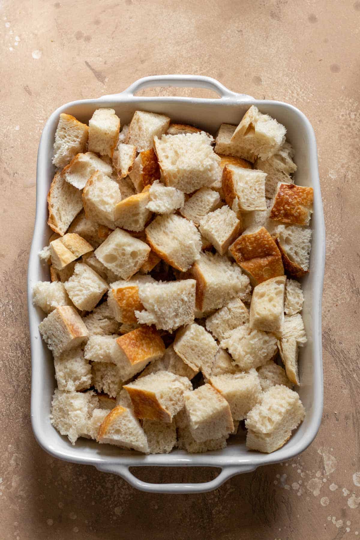 Cubed french bread in a greased casserole dish.