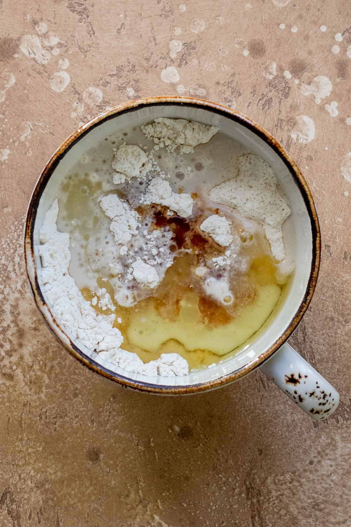 Wet ingredients added into mug with dry ingredients.