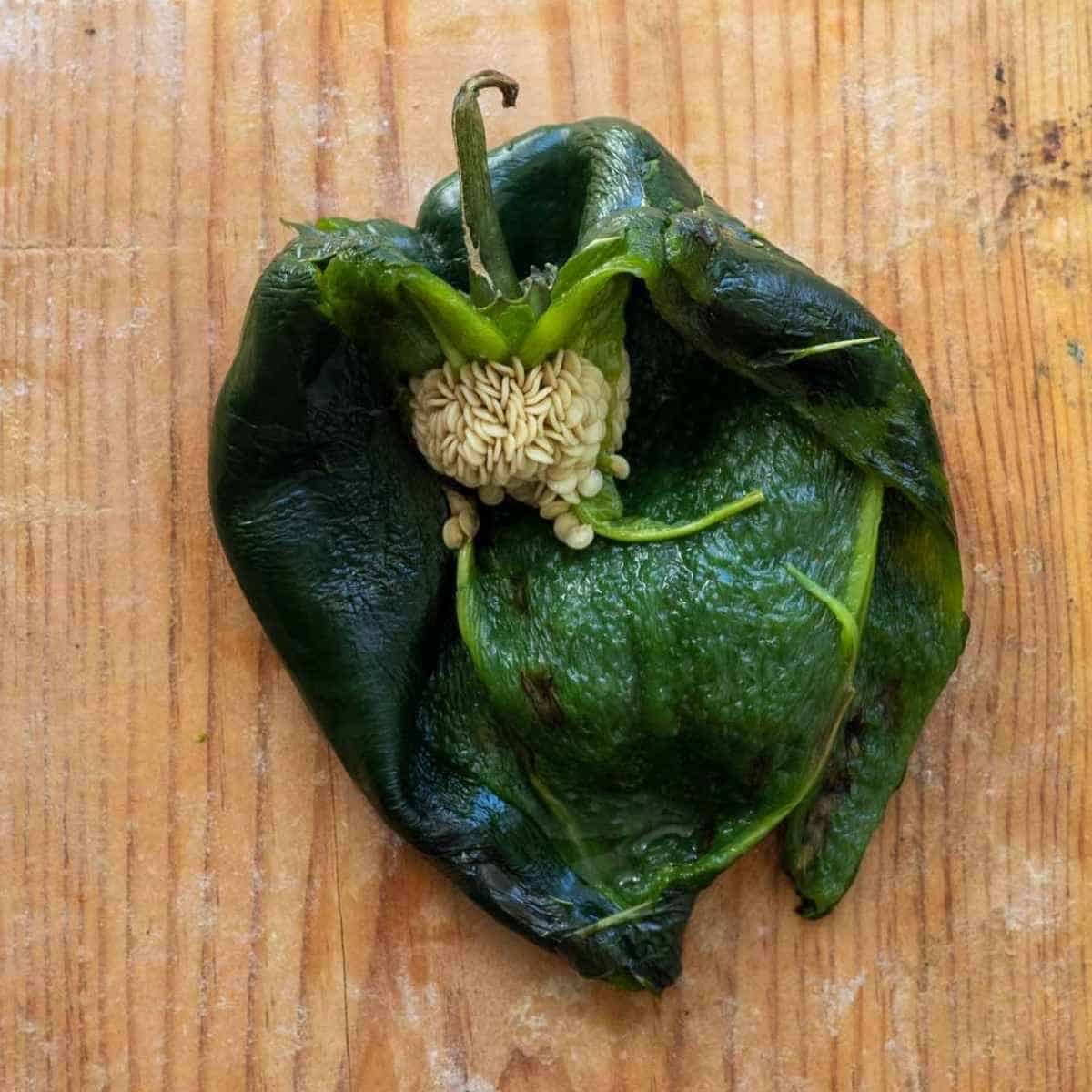 Poblano pepper sliced in half exposing seeds.