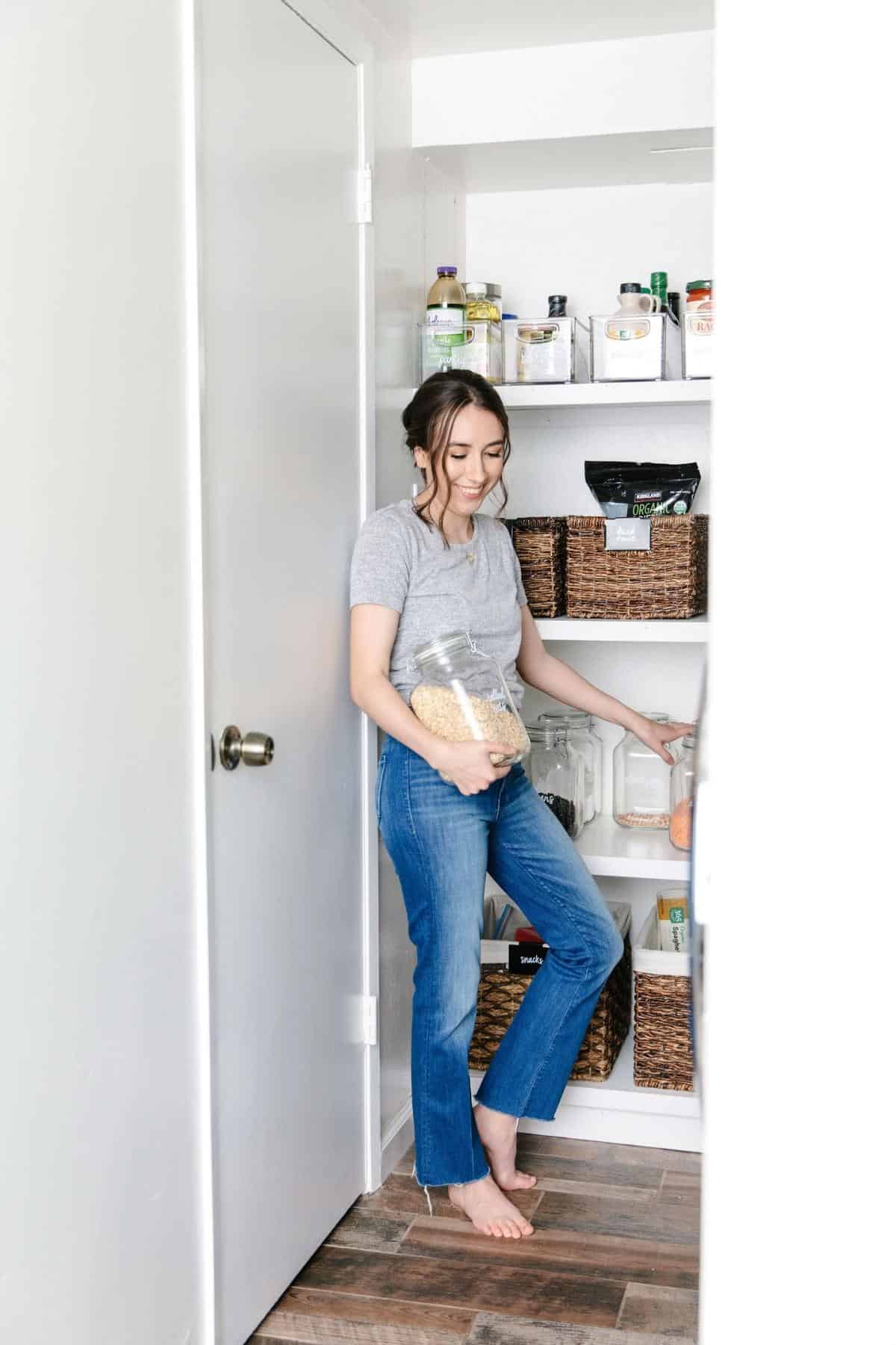Nicolette in pantry holding glass bulk jar.