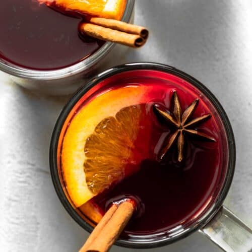 Non-alcoholic mulled wine in mug garnished with orange slice, star anise, and cinnamon.