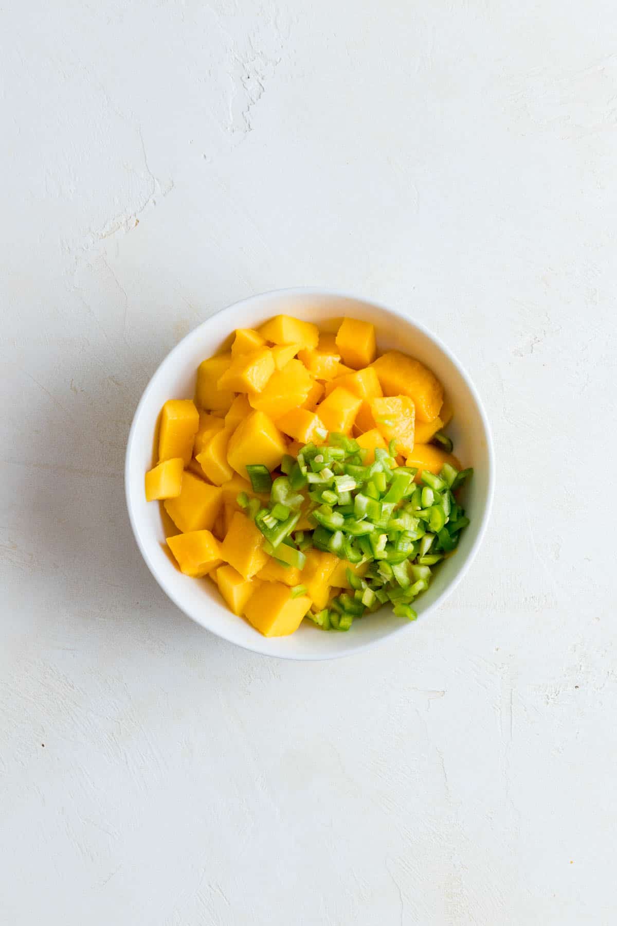 Mango and peppers in bowl.