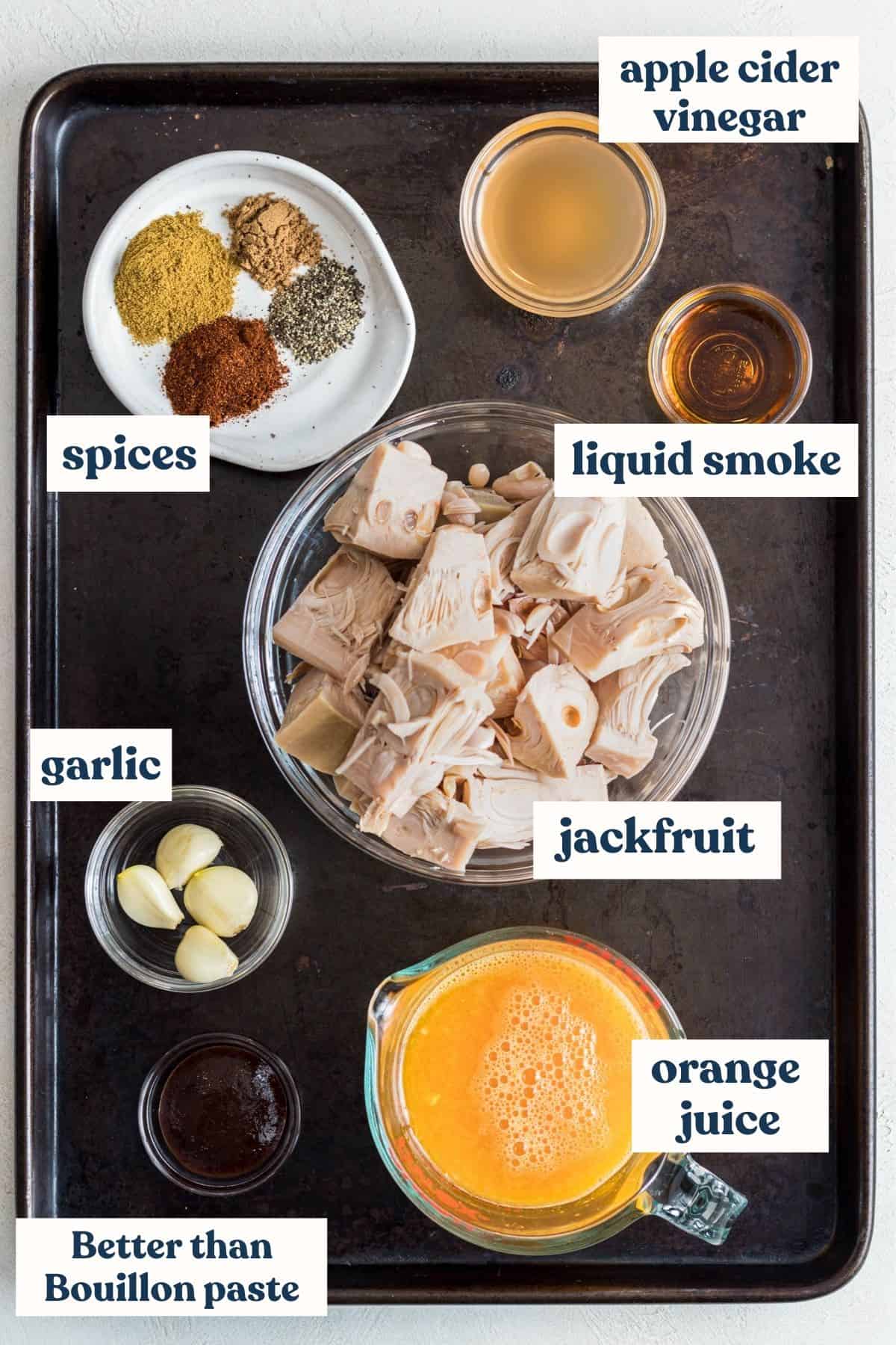 Jackfruit carnitas ingredients with labels on baking sheet.