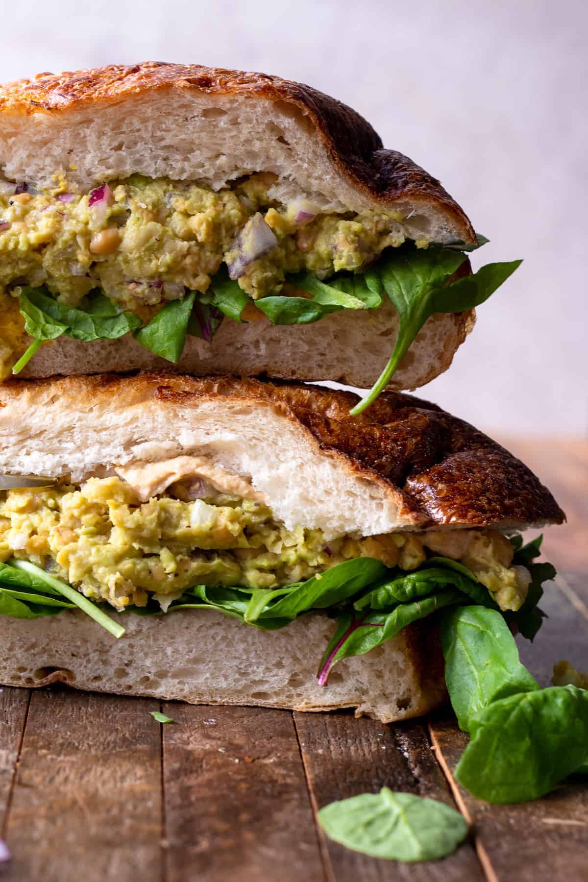 Chickpea avocado salad on french bread with spinach and hummus.
