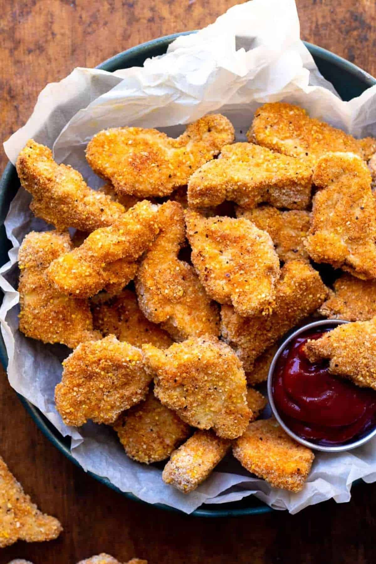 Tofu chicken nuggets in bowl with ketchup dipping bowl.