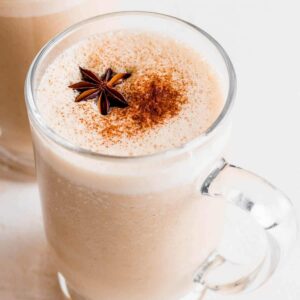 Chai latte in glass mug dusted with cinnamon.