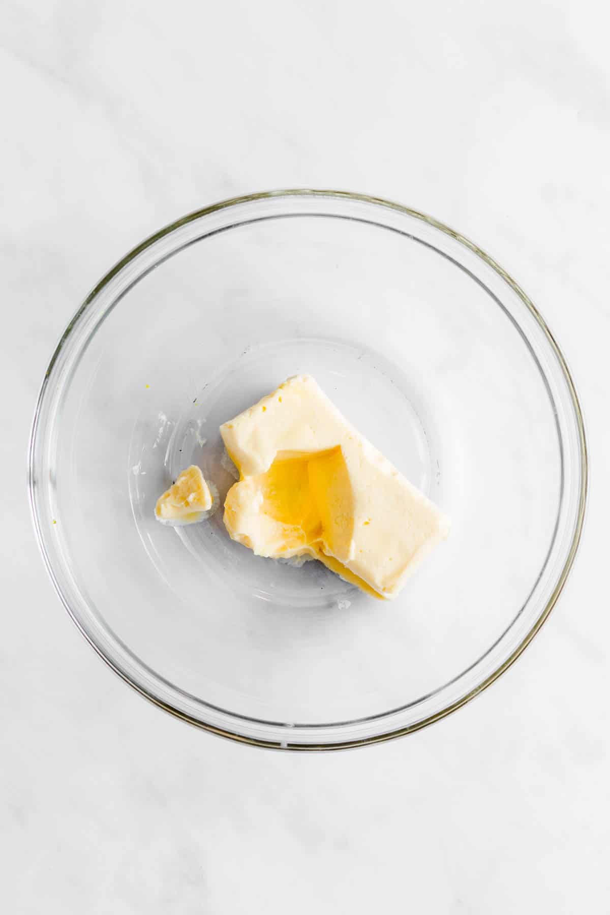 Softened butter in a glass mixing bowl.