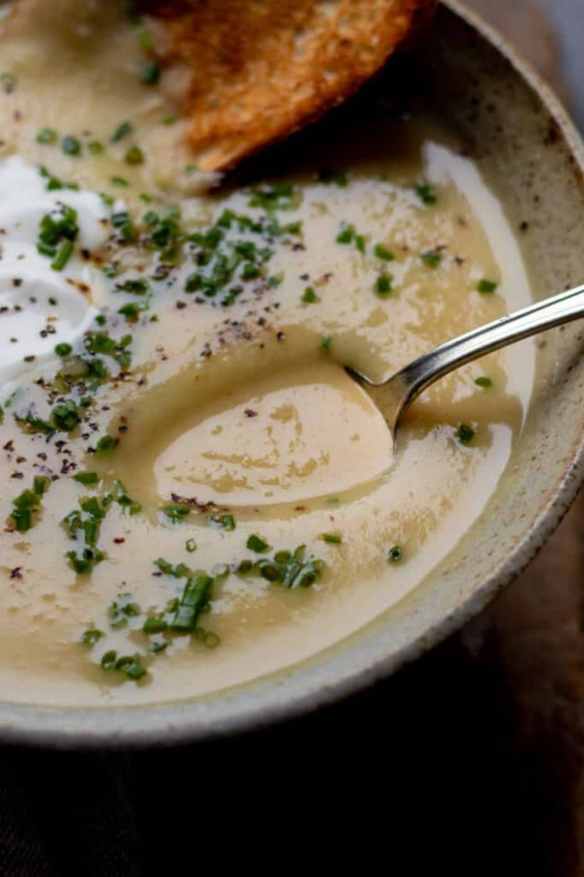 A spoonful of soup closeup in ceramic bowl.