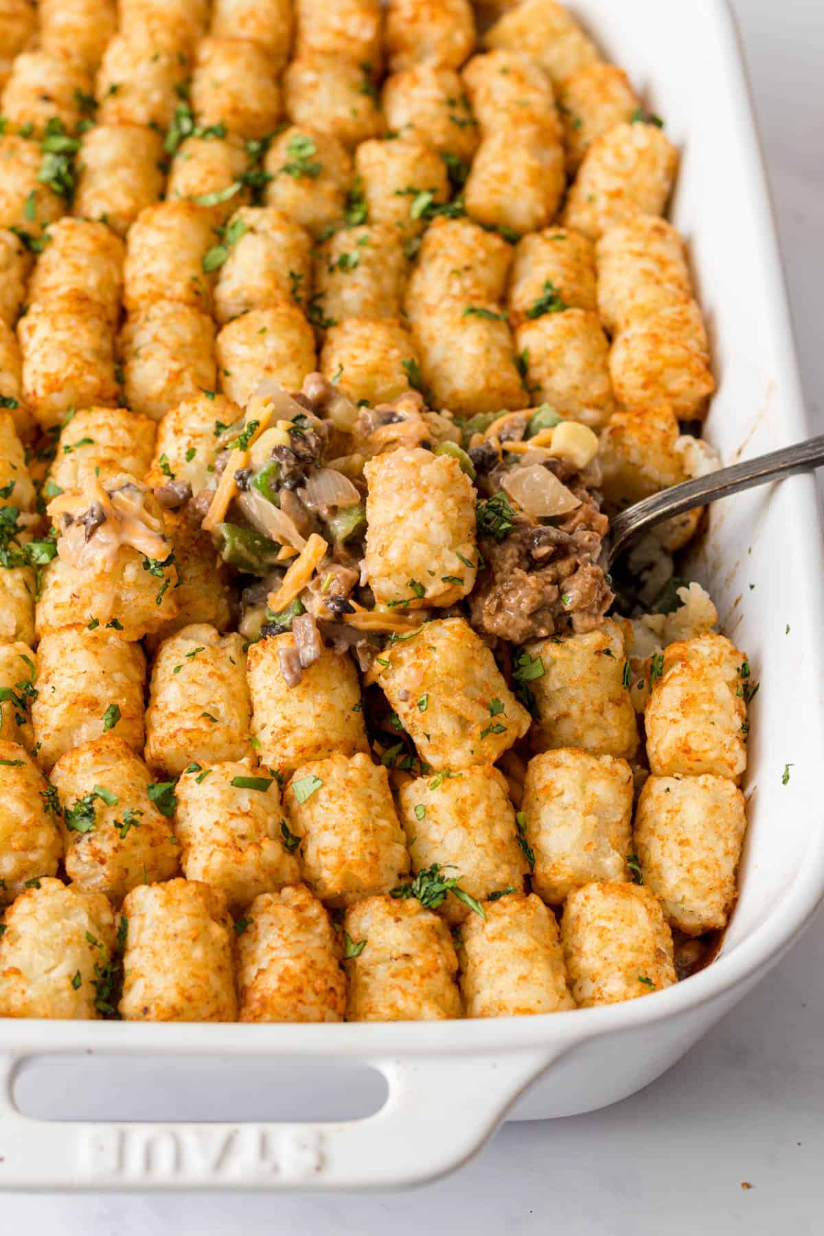 Tater tot casserole in white dish.