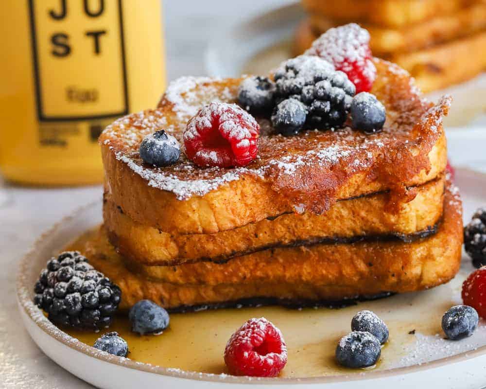 Stack of french toast with JUST Egg bottle in the background.