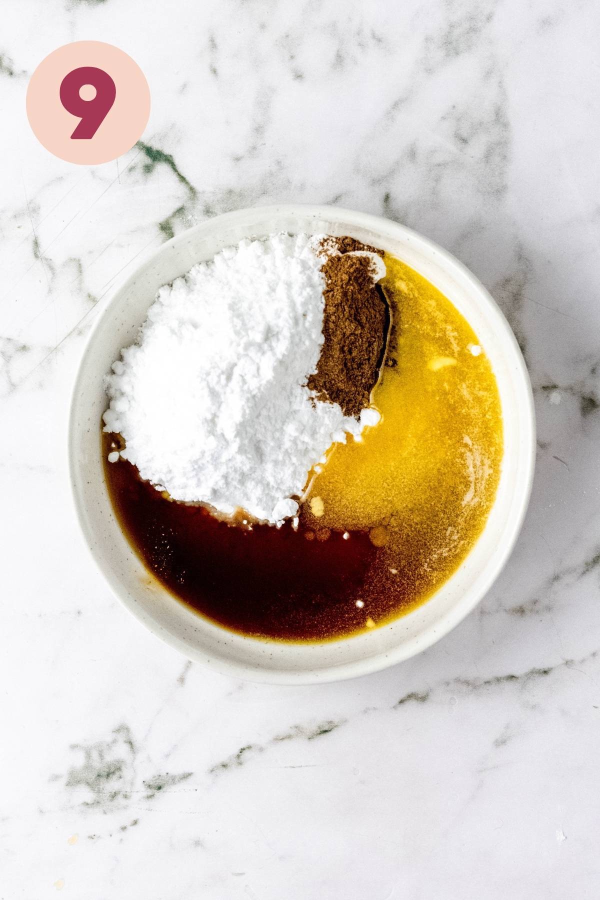 Powdered sugar, maple syrup, vegan butter, and pumpkin spice added to a small bowl.