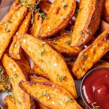 Sweet potato wedges sprinkles with salt and served with ketchup.