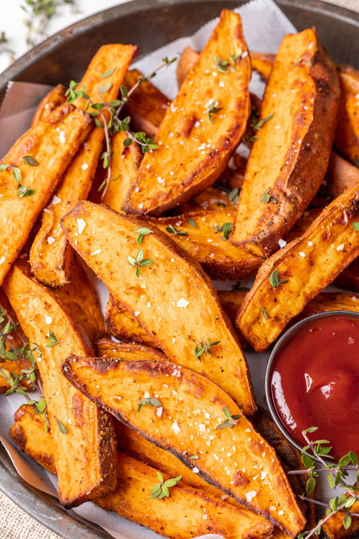 Sweet potato wedges sprinkles with salt and served with ketchup.
