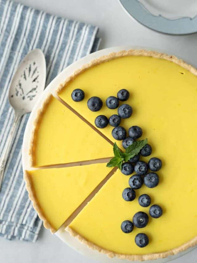 Lemon tart with two slices cut in it.
