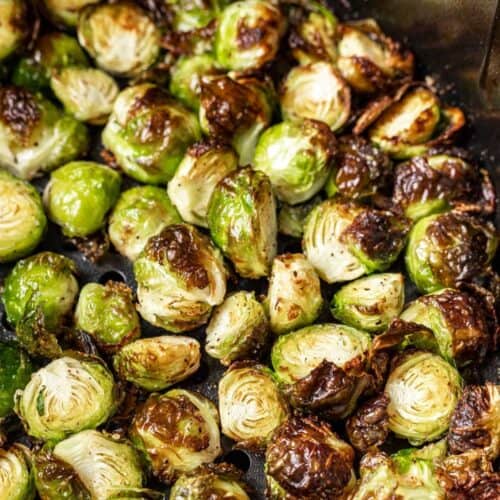 Bowl of crispy air fryer Brussels sprouts with a spoon.