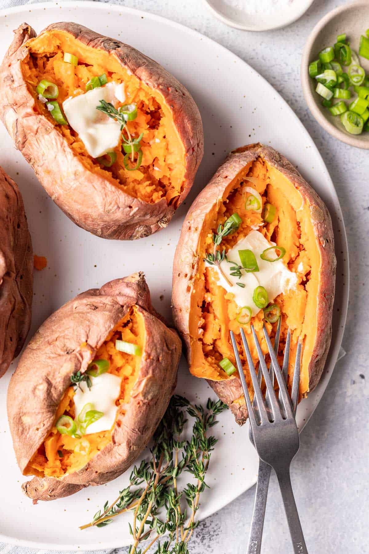 3 sweet potatoes with butter and 2 forks.