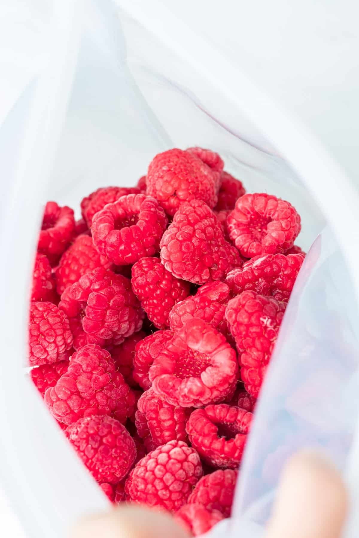 Open bag of frozen raspberries.