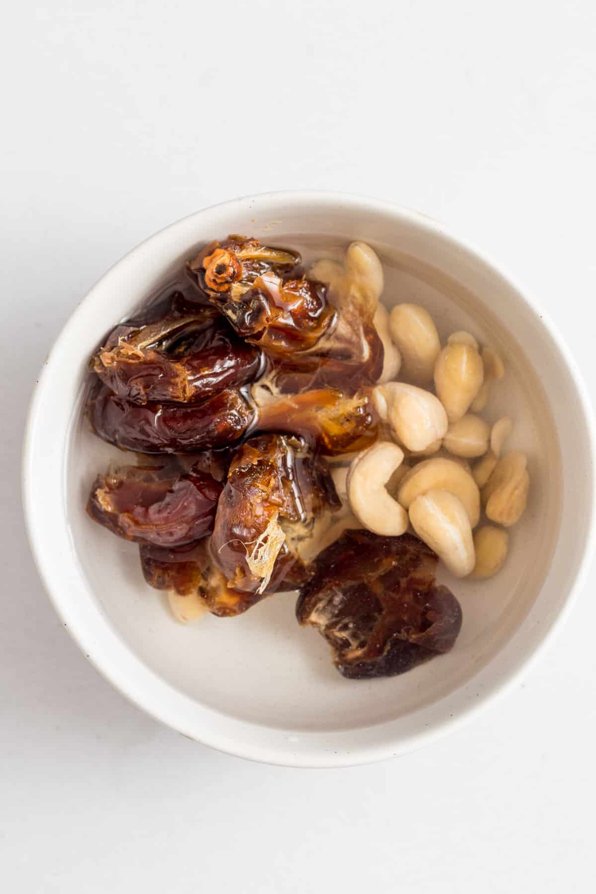 Soaking dates and cashews in hot water.