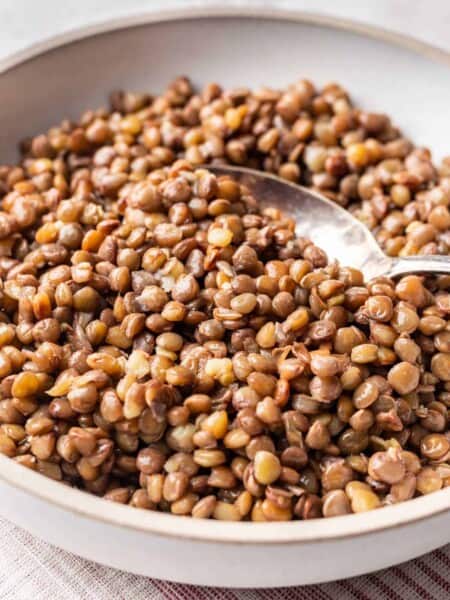 Bowl of green lentils with spoon.