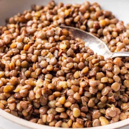 Bowl of green lentils with spoon.