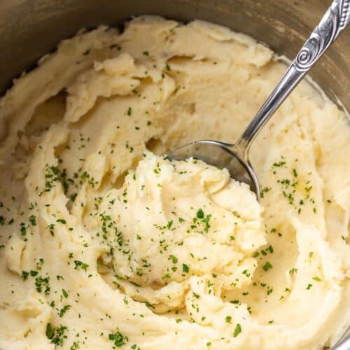 Mashed potatoes in the Instant Pot with a serving spoon.