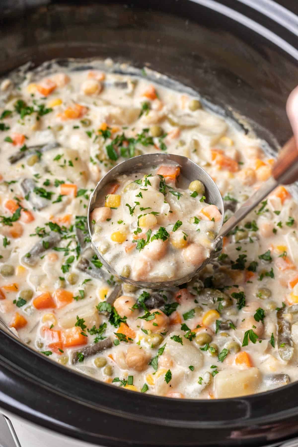 Slow cooker filled with vegan pot pie filling.