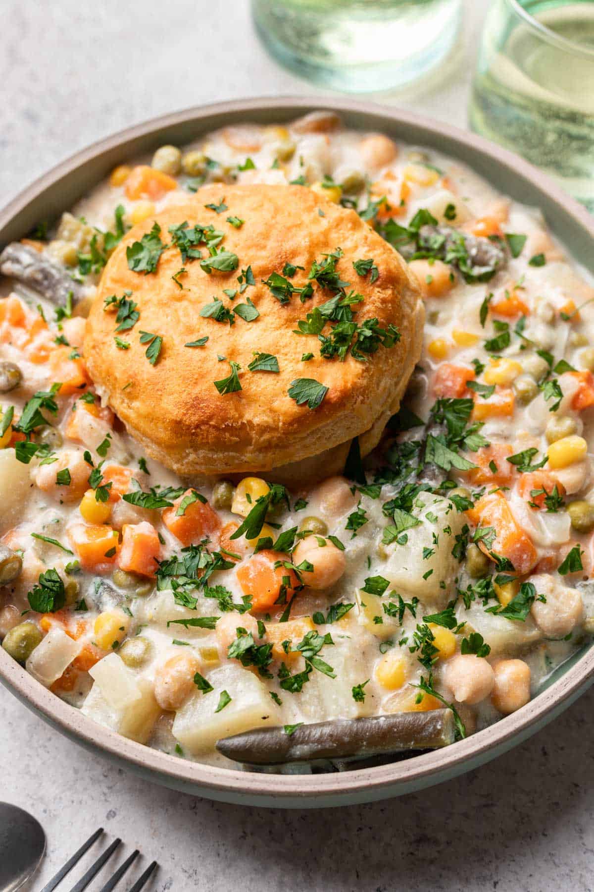 Closeup of bowl of pot pie with biscuit on top.