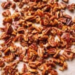 Glazed pecans on sheet pan lined with parchment paper.