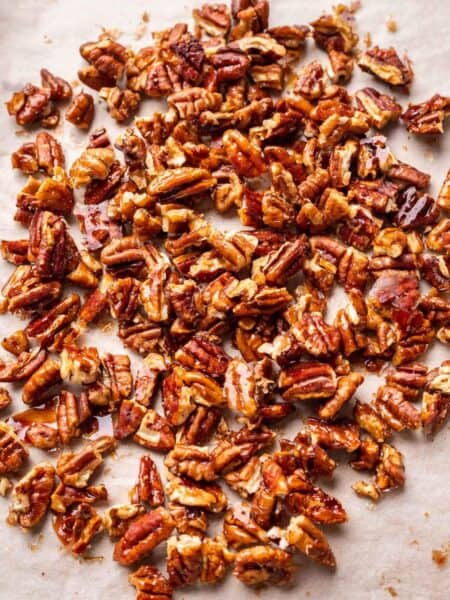 Glazed pecans on sheet pan lined with parchment paper.