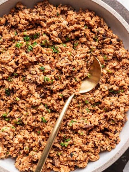 Vegan ground beef in a bowl with a gold spoon.