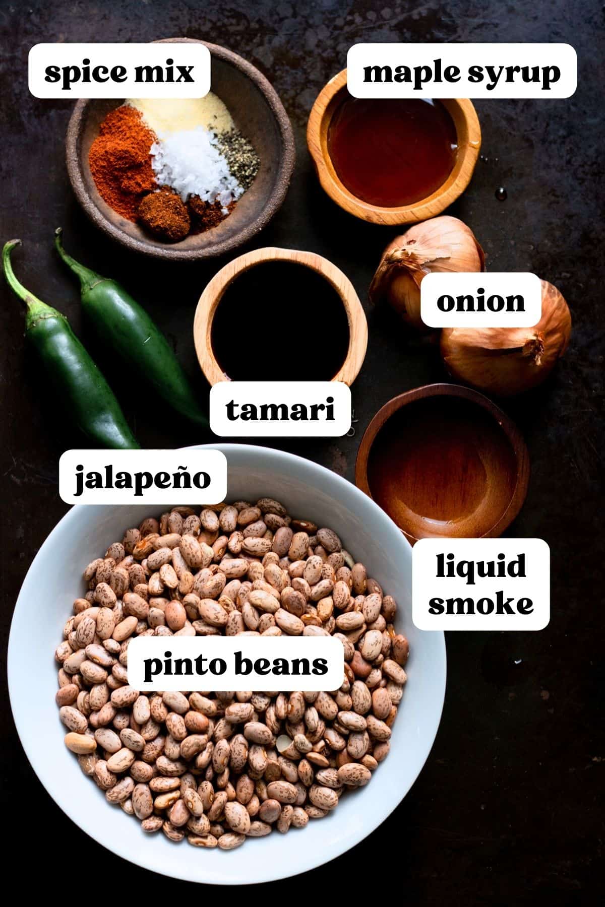 Ingredients to make insant pot refried beans measured and labeled on dark backdrop.