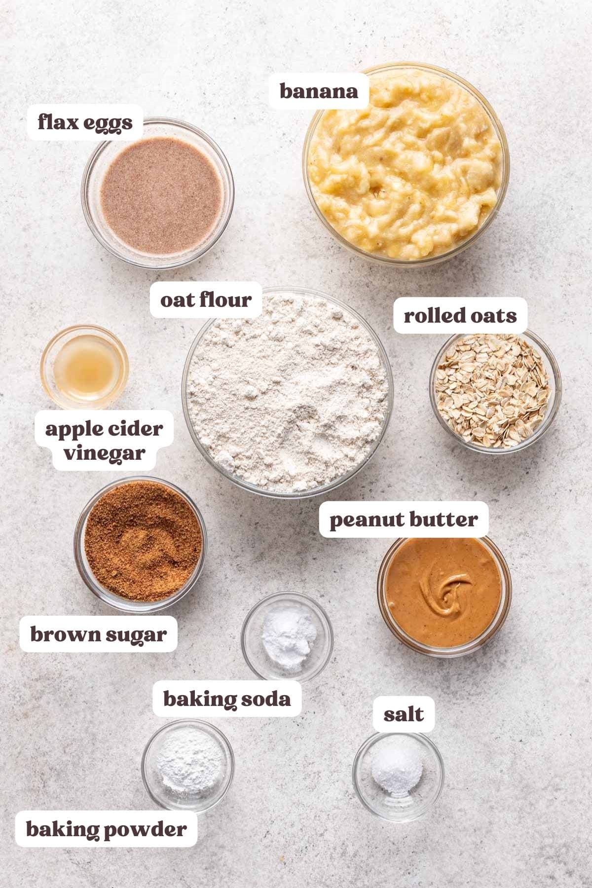 Overview of ingredients you need to make these peanut butter banana oatmeal muffins. Ingredients measured in glass bowls.